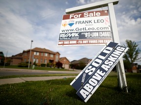 A real estate sign that reads "For Sale" and "Sold Above Asking" stands in front of housing in Vaughan, May 24, 2017.