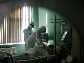 Medical specialists treat a patient suffering from COVID-19 at the intensive care unit (ICU) of the City Clinical Hospital named after S.Botkin in Oryol, Russia, Oct. 26, 2021.