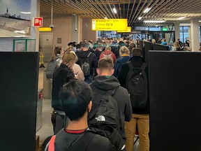 Passengers travelling from South Africa queue to be tested for COVID-19 after being held on the tarmac at Schiphol Airport, Netherlands November 26, 2021, in this picture obtained from social media.