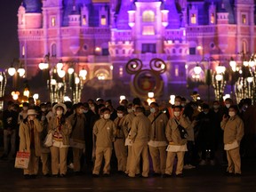 This photo taken on Oct. 31, 2021 shows people preparing to undergo nucleic acid tests for the COVID-19 coronavirus at Shanghai Disneyland, as the park closed over a single coronavirus case.