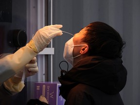 A man undergoes a COVID-19 test at a testing site in Seoul, Nov. 10, 2021.