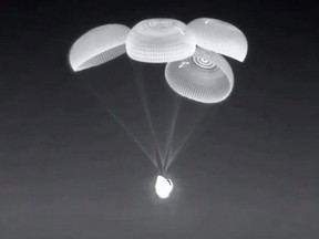 This screen grab taken from the SpaceX live webcast shows the Crew-2 SpaceX Dragon capsule dubbed "Endeavour" with its parachutes deployed just before splashing down off the coast of Pensacola, Florida, on November 8, 2021.