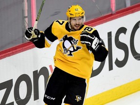 Penguins captain Sidney Crosby celebrates a goal by teammate Bryan Rust against the Islanders during the first round of the 2021 Stanley Cup Playoffs at PPG PAINTS Arena in Pittsburgh, May 24, 2021.