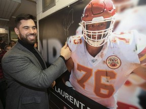 Laurent Duvernay-Tardif signs a banner of himself which was unveiled at the McGill sports centre in Montreal on Feb. 12, 2020. Duvernay-Tardif was traded from the Kansas City Chiefs to the New York Jets on Nov. 2, 2021.