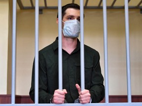 In this file photo taken on July 30, 2020, ex-Marine Trevor Reed, charged with attacking police, stands inside a defendants' cage during his verdict hearing at Moscow's Golovinsky district court.