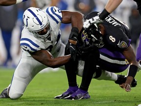 Lamar Jackson, right, of the Baltimore Ravens is tackled by Tyquan Lewis of the Indianapolis Colts during the  in a game  at M&T Bank Stadium on Oct. 11, 2021 in Baltimore.