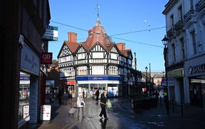 Pedestrians walk past shops in the town centre in Wrexham (Photo by PAUL ELLIS/AFP via Getty Images)