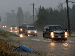A car sits in a ditch on a flooded stretch of road after rainstorms lashed the western Canadian province of British Columbia, triggering landslides and floods, shutting highways, in Chilliwack November 15, 2021.