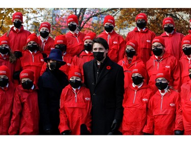 Prime Minister Justin Trudeau and his wife Sophie Gregoire pose with a children's choir during a ceremony at the National War Memorial on Remembrance Day in Ottawa, Nov. 11, 2021.