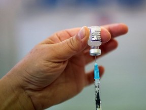 A health worker prepares a dose of the COVID-19 booster vaccine