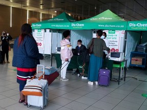Passengers queue to get a PCR test against the coronavirus disease (COVID-19) before traveling on international flights, at O.R. Tambo International Airport in Johannesburg, South Africa, November 26, 2021.