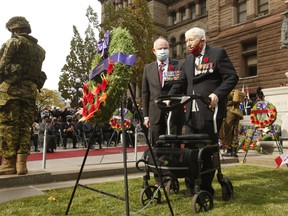 (L) Retired Major General Dave Fraser, former Canadian Forces commander in Afghanistan, assists Second World War veteran Marvin Gord as the 100-year-old lays a wreath at the Old City Hall cenotaph during a Remembrance Day ceremony on Thursday, Nov. 11, 2021.