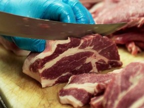 Canadian pork shoulders are prepped on a butcher's counter in Toronto in this file photo.