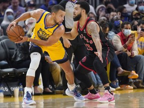 Warriors’ Stephen Curry (left) is defended by Raptors’ Fred VanVleet during the first half in San Francisco last night.