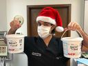 Dr. Giancarlo McEvenue, a plastic surgeon who performed female-to-male chest surgeries at McLean Clinic in Mississauga, holds two medical waste buckets labelled 