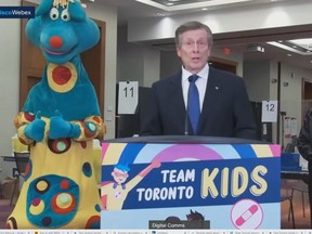 Toronto Mayor John Tory, right, speaks with Polkaroo during a press conference at the city-run COVID vaccine clinic at the Metro Toronto Convention Centre on Wednesday, Nov. 24 2021