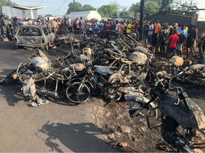 ople watch burnt car and motorcycles after a fuel tanker explosion in Freetown, Sierra Leone November 6, 2021.