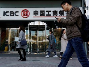 People walk past a branch of Industrial and Commercial Bank of China (ICBC) in Beijing, China April 1, 2019.  ]
