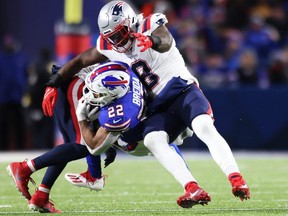 Myles Bryant (41) and Ja'Whaun Bentley (8) of the New England Patriots tackle Matt Breida of the Buffalo Bills during the second quarter at Highmark Stadium on Dec. 06, 2021 in Orchard Park, New York.