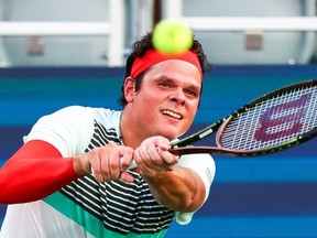 Milos Raonic of Canada returns a shot from Brandon Nakashima of the United States during a match at the Truist Atlanta Open at Atlantic Station on July 28, 2021 in Atlanta, Georgia.