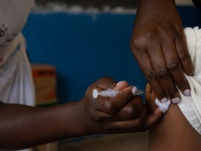 A nurse injects a patient with their second dose of AstraZeneca vaccine on September 29, 2021 in Kampala, Uganda.