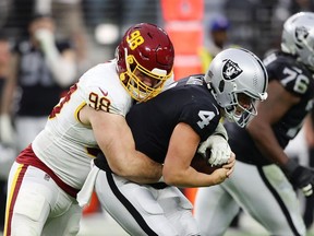 Matt Ioannidis of the Washington Football Team sacks Derek Carr of the Las Vegas Raiders during the third quarter at Allegiant Stadium on December 05, 2021 in Las Vegas, Nevada.