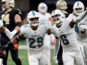Brandon Jones #29 of the Miami Dolphins celebrates getting an interception with teammate Jevon Holland #8 in the fourth quarter of the game against the New Orleans Saints at Caesars Superdome on December 27, 2021 in New Orleans, Louisiana.