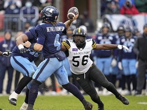 Tiger-Cats defensive end Ja’Gared Davis (right) pressure Argonauts quarterback McLeod Bethel-Thompson during the Eastern Division final yesterday.