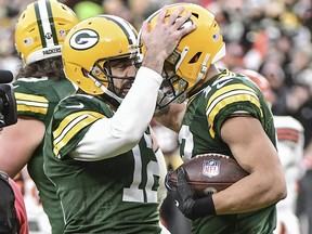 Green Bay Packers quarterback Aaron Rodgers, left, celebrates with wide receiver Allen Lazard after setting the franchise record for most passing TDs in the first quarter during the game against the Cleveland Browns at Lambeau Field in Green Bay, Wis., Dec. 25, 2021.