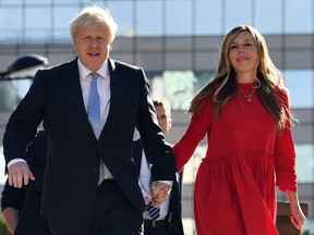 In this file photo taken on Oct. 6, 2021, Britain's Prime Minister Boris Johnson and his wife Carrie arrive at the Manchester Central convention centre ahead of his keynote speech on the final day of the annual Conservative Party Conference in Manchester, northwest England.