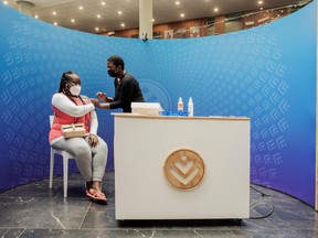 A woman receives a dose of the Pfizer/BioNTech vaccine against COVID-19 at Discovery vaccination site in Sandton, Johannesburg, on December 15, 2021.