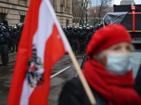 A protester hold the Austria flag as police block a rally against COVID-19 restrictions and mandatory vaccination in Frankfurt am Main, western Germany, on Dec. 4, 2021 amid the ongoing coronavirus pandemic.