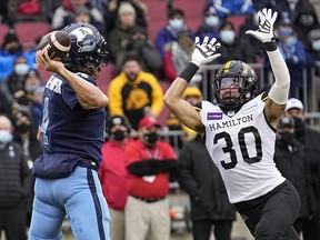 Argonauts QB McLeod Bethel-Thompson (4) goes to throw a pass as Tiger-Cats defensive back Stavros Katsantonis (30) closes in during first half action in the CFL Eastern Conference Final game at BMO Field in Toronto, Sunday, Dec. 5, 2021.