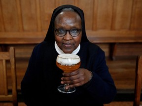 Benedictine Sister Gertrude drinks a "Maredret" beer during an interview with Reuters at the Maredret Abbey, which signed a partnership with the Anthony Martin brewing group to produce two beers labeled "Maredret," with ingredients inspired by the monastery garden, in Anhee, Belgium, Dec. 8, 2021.