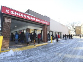 People line up outside a Shoppers Drug Mart on the Royal York Rd. and The Kingsway for booster shots on Sunday, December 19, 2021.