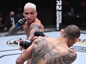 In this handout image provided by UFC, Charles Oliveira of Brazil punches Tony Ferguson in their lightweight bout during the UFC 256 event at UFC APEX on December 12, 2020 in Las Vegas.