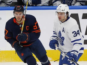 Edmonton Oilers forward Connor McDavid (left) and Maple Leafs forward Auston Matthews look for a loose puck at Rogers Place in Edmonton.