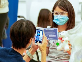 Lily Cho takes a photo of her daughter Harriet Cho after she received her vaccine at a Humber River Hospital vaccination clinic after Canada approved Pfizer's coronavirus disease (COVID-19) vaccine for children aged 5 to 11, in Toronto, November 25, 2021.