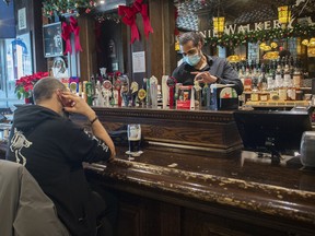 Tim Rowhani pours a pint behind the bar at McKibbin’s Irish Pub on St-Laurent Boulevard in Montreal, Monday, December 20, 2021,