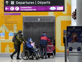 People travel at Pearson International Airport during the COVID-19 pandemic in Toronto, Friday, Dec. 3, 2021.