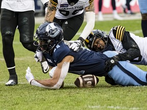 Argos wide receiver Juwan Brescacin has a pass attempt broken up by Hamilton Tiger-Cats defensive back Ciante Evans during yesterday’s East final at BMO Field.