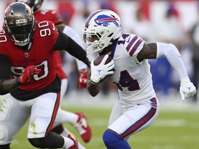 Buffalo Bills wide receiver Stefon Diggs (14) runs away from Tampa Bay Buccaneers linebacker Jason Pierre-Paul (90) after a catch during the first half of an NFL football game Sunday, Dec. 12, 2021, in Tampa, Fla.