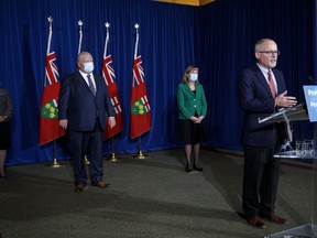 Ontario's Chief Medical Officer of Health, Dr. Kieran Moore speaks as Ontario Premier Doug Ford is flanked by Solicitor General Sylvia Jones, left, and minister of health Christine Elliott in the background, during a press conference at Queen's Park in Toronto, Wednesday, Dec. 15, 2021.