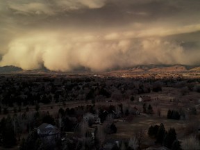 A cloud of dust storm is observed in Niwot, Col., Dec. 15, 2021 in this screen grab obtained from a social media video.