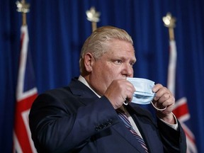 Ontario Premier Doug Ford puts his mask back on after speaking during a press conference at Queen's Park in Toronto on Dec. 15, 2021.