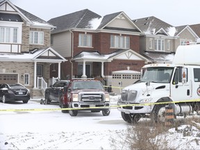 A tow truck removes a black Jeep SUV while Durham Regional Police canvas an area of Ajax after a man was shot at a home located at 45 Denny St. on Monday, December 27, 2021.