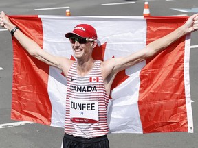 Evan Dunfee of Canada celebrates with his national flag after winning bronze in the 2020 Olympics.