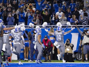 Detroit Lions wide receiver Amon-Ra St. Brown (14) runs to celebrate with the fans after making the game winning touchdown catch in the final seconds of the fourth quarter against the Minnesota Vikings at Ford Field Dec. 5, 2021.