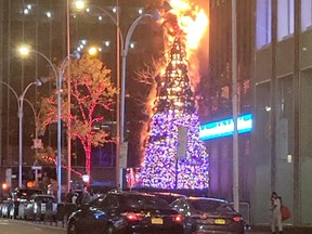 A Christmas tree burns outside Fox News building in New York City, December 8, 2021 in this still image obtained from a social media video.