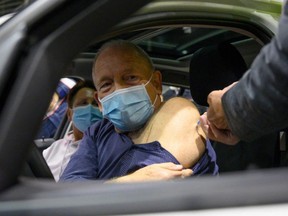 Patient Mathias Stirm receives a vaccination with the BioNTech vaccine in his car at a drive-in COVID-19 vaccination station in Stuttgart, Germany, Friday, Dec. 17, 2021.